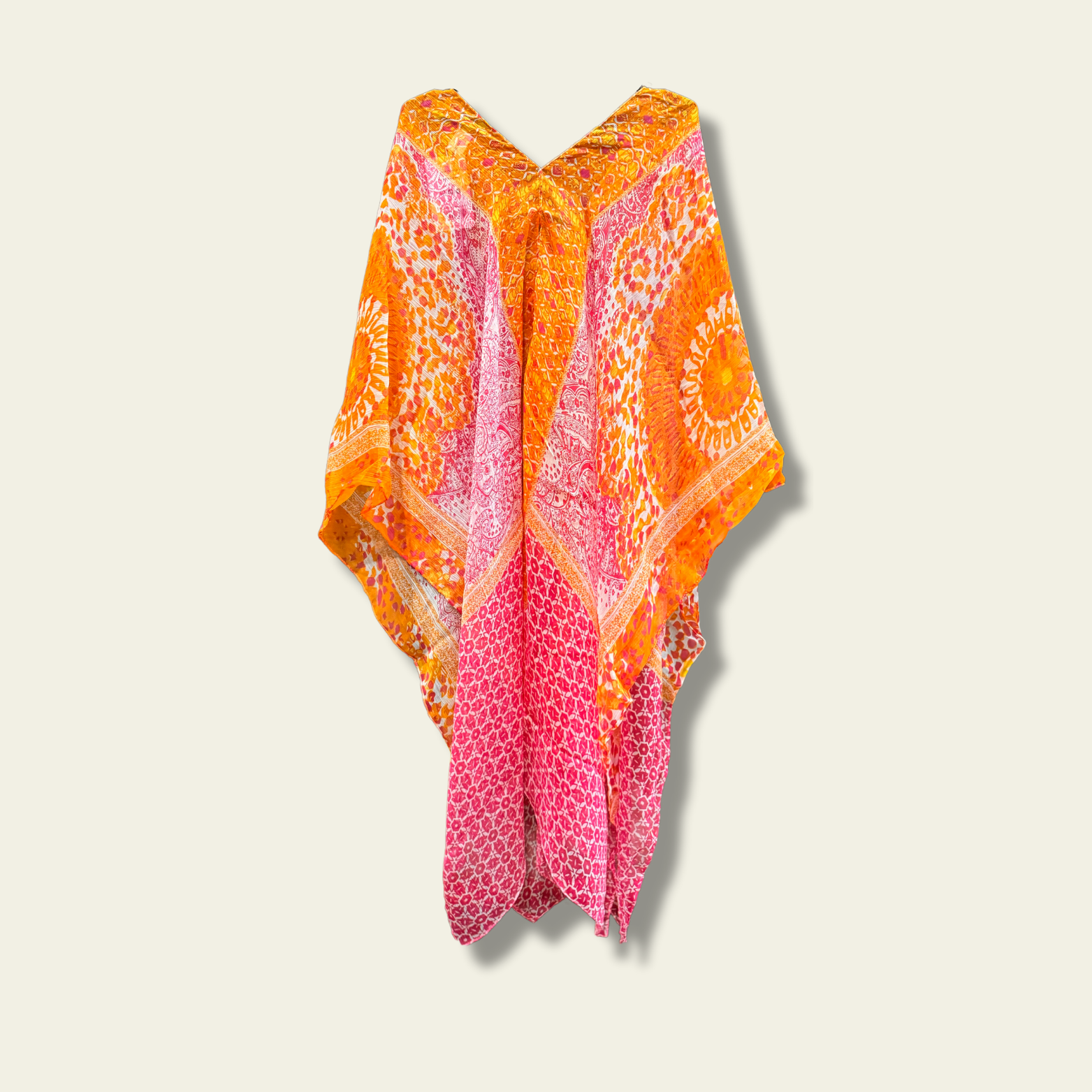 This lightweight chiffon poncho drapes beautifully, showcasing a vibrant blend of orange and pink. 