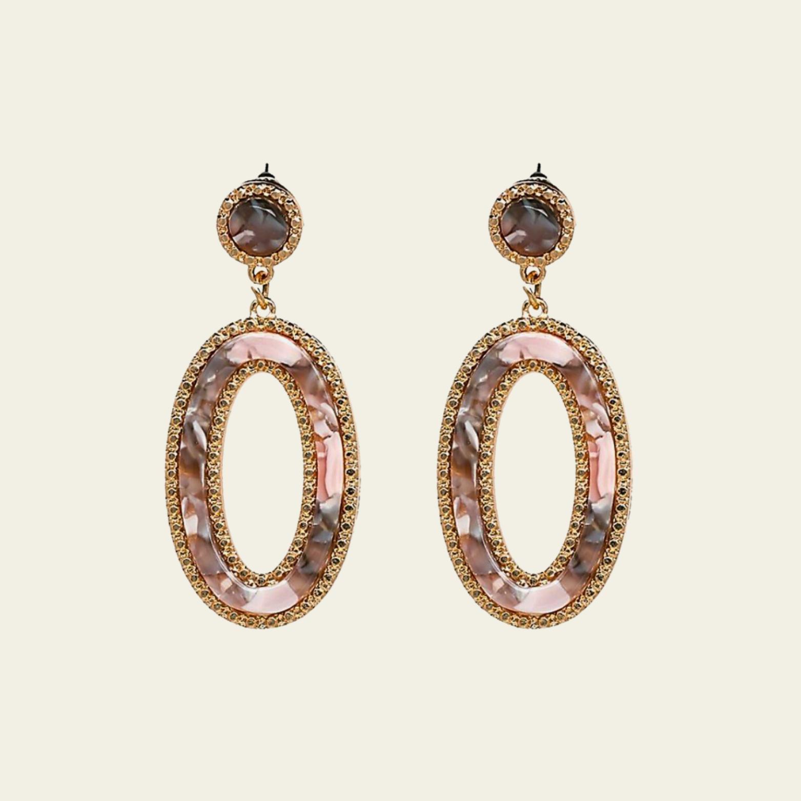 These stunning chandelier earrings feature two hanging oval-shaped pendants, each designed with a beautiful pink marble effect on the inside. The soft pink tones are complemented by subtle veining, giving them a sophisticated, marble-like appearance. The outer edges of the ovals are accented with delicate gold detailing.