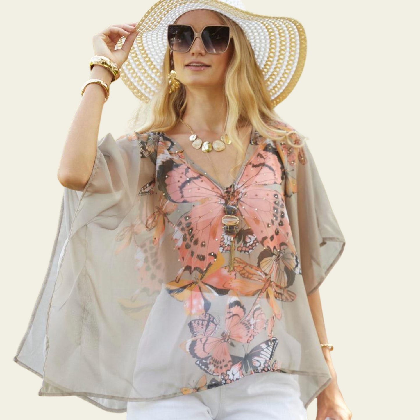 The Bijoux Terner Crystal Top Breathable Blouse is elegantly worn by the model, showcasing its lightweight fabric and graceful drape. The blouse flows effortlessly, highlighting its airy and breathable quality, perfect for warm weather. The design features a vibrant butterfly print in a mix of colorful hues, with shades of taupe that complement the intricate details of the butterflies. 