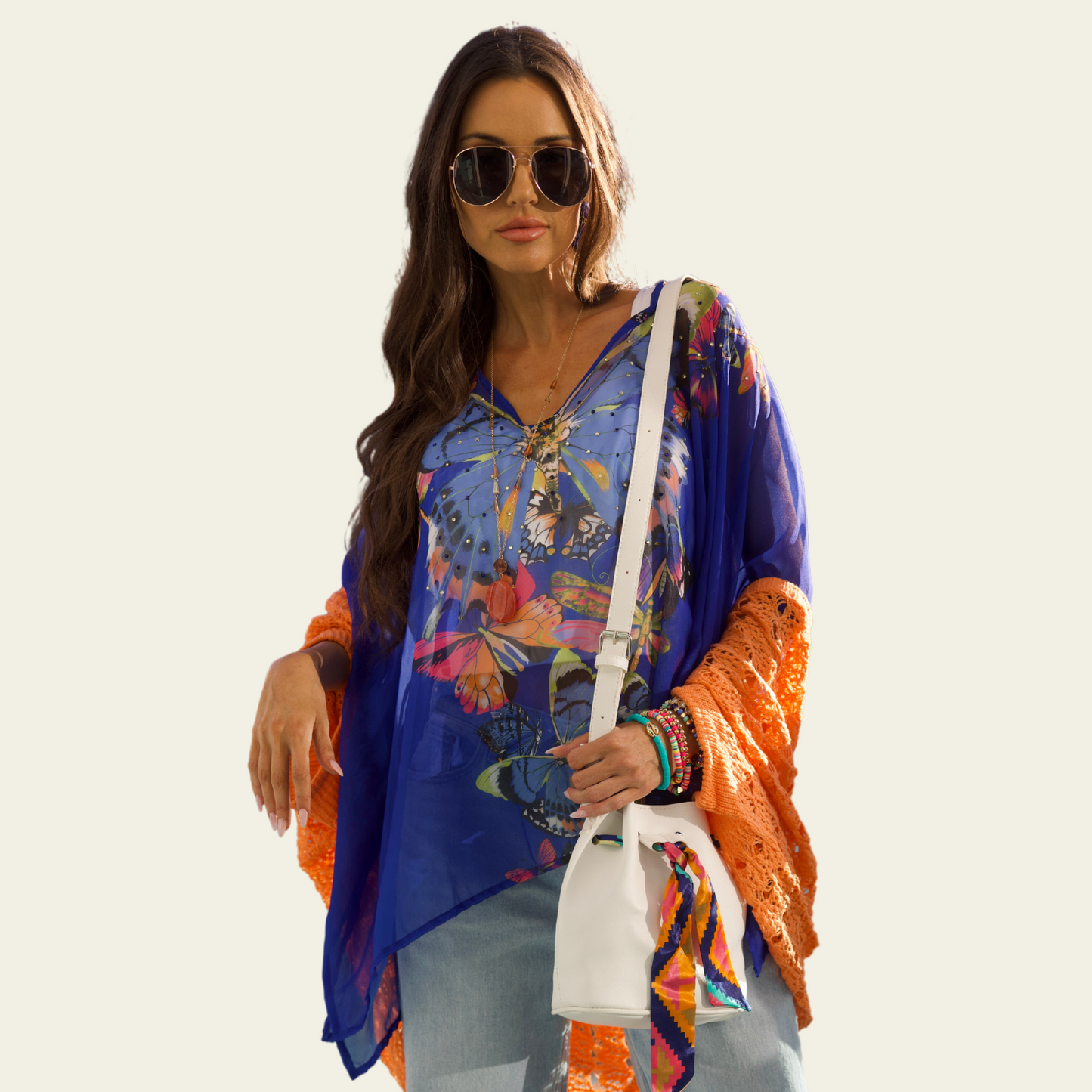 The Bijoux Terner Crystal Top Breathable Blouse is elegantly worn by the model, showcasing its lightweight fabric and graceful drape. The blouse flows effortlessly, highlighting its airy and breathable quality, perfect for warm weather. The design features a vibrant butterfly print in a mix of colorful hues, with shades of blue that complement the intricate details of the butterflies. 