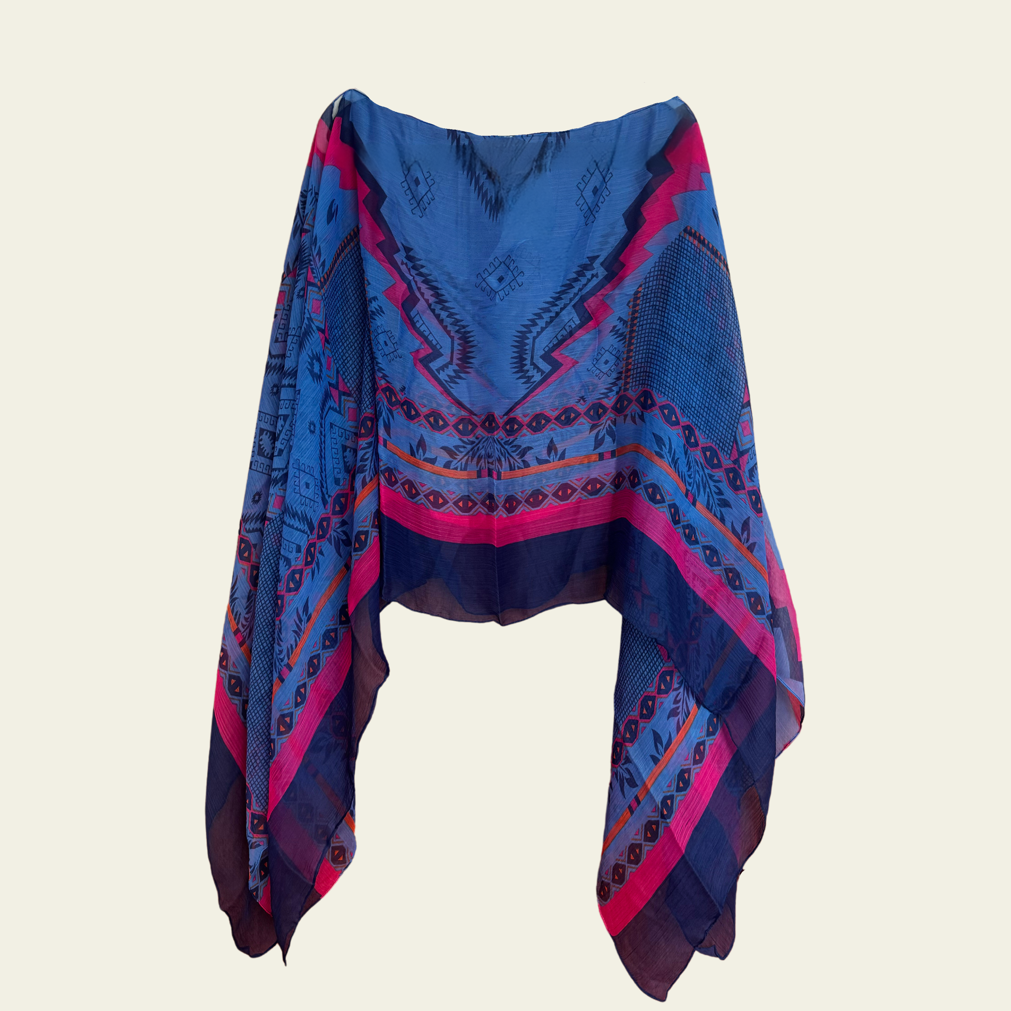 This lightweight chiffon poncho drapes beautifully, showcasing a vibrant blend of blue and pink with an abstract print. 