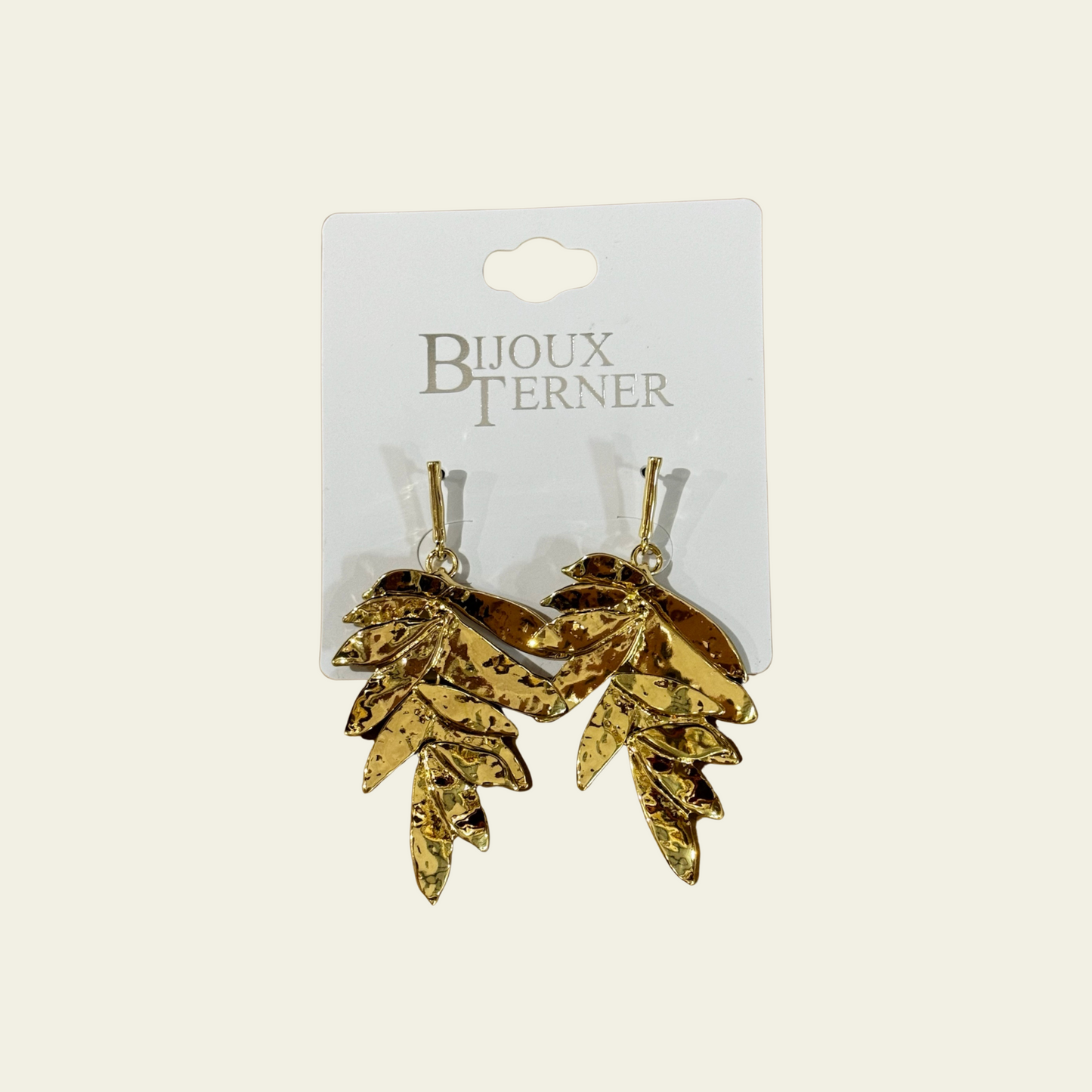 These striking chandelier earrings feature a bold, tropical-inspired design, with golden palm leaves that cascade gracefully. The earrings are entirely made of gold-tone metal, with the leaves arranged to create an elegant, flowing look as they fall from the ear