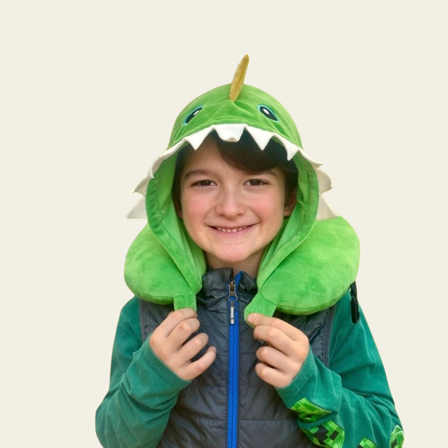 This adorable neck pillow with a hood for kids is designed to provide comfort and support during travel. Shaped like a cute green dinosaur, it offers a fun and cozy experience for children while they rest on long car rides, flights, or during naps. The soft and plush material ensures comfort, while the pillow’s ergonomic design helps support the neck for a more relaxed journey.