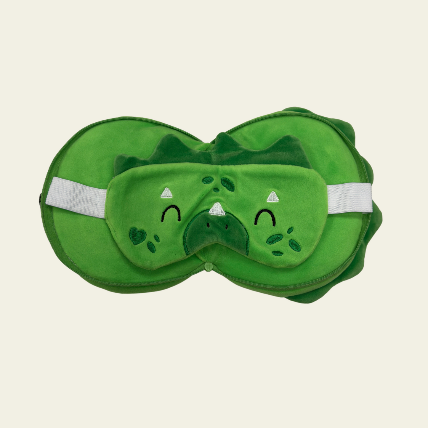 This soft and comfortable eye mask pillow for kids is designed in the shape of a cute reptile. The pillow is made of high-quality, gentle materials to provide a cozy and relaxing experience for children. It helps block out light for a restful sleep or nap, making it perfect for travel or bedtime. The pillow is lightweight and features a fun, reptile design with a green color and colorful accents.