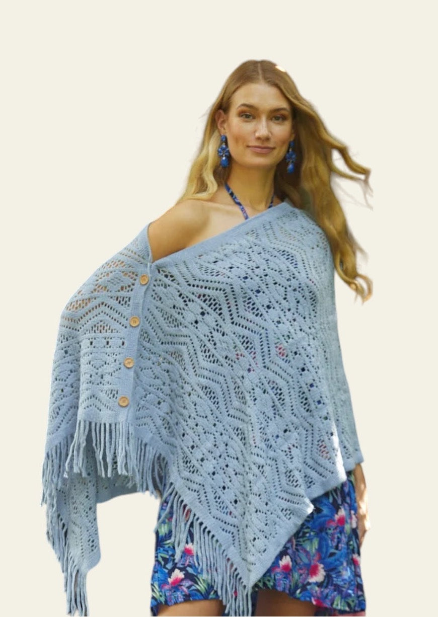 The knitted blue Cardishawl is elegantly worn by the model, draped over one shoulder to reveal a relaxed, flattering fit. The soft, textured knit creates a cozy and breathable feel, while the loose, open design adds effortless charm and movement. The piece falls gracefully, offering a stylish, laid-back look that remains both comfortable and chic. Ideal for layering over casual or dressy outfits.