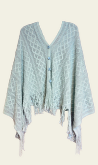 Knitted Cardishawl. The soft, textured knit creates a cozy and breathable feel, while the loose, open design adds effortless charm and movement. The piece falls gracefully, offering a stylish, laid-back look that remains both comfortable and chic. 