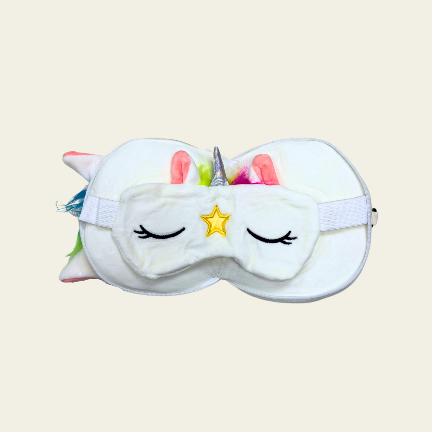 This soft and comfortable eye mask pillow for kids is designed in the shape of a cute white unicorn. The pillow is made of high-quality, gentle materials to provide a cozy and relaxing experience for children. It helps block out light for a restful sleep or nap, making it perfect for travel or bedtime. The pillow is lightweight and features a fun, whimsical unicorn design with a white color and colorful accents.