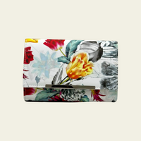 The Bijoux Terner Fashion Floral Print Clutch features a sleek white background that serves as a striking contrast to the vibrant, colorful floral print. The bold, intricate flowers in a mix of bright hues stand out against the beige backdrop, creating a lively and eye-catching design. 