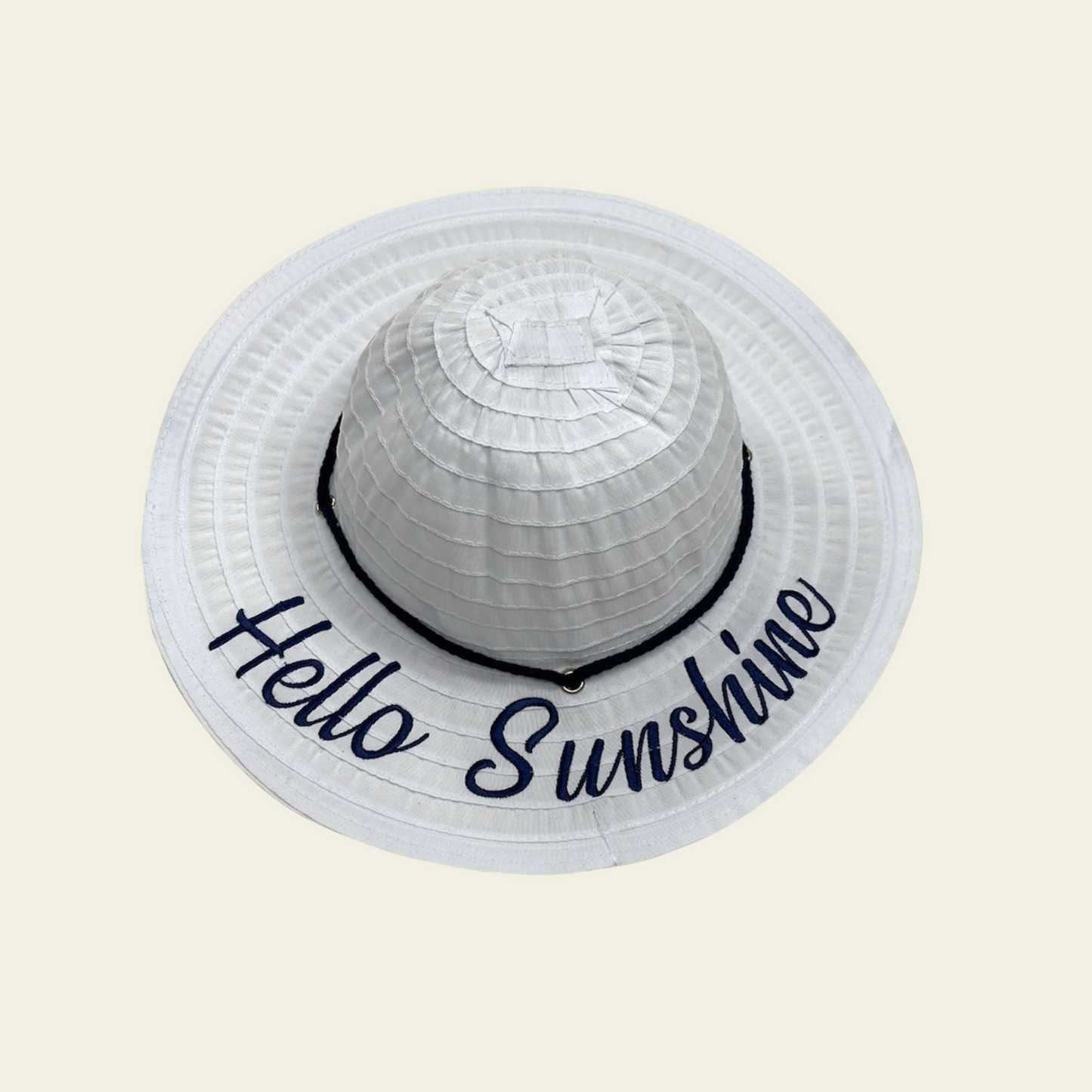 This kids' hat features a white crushable design, making it easy to pack and store when not in use. Made from lightweight, durable fabric, it is designed to provide comfort and sun protection. The hat features a printed quote "hello sunshine" on the front, adding a fun and personal touch to your child's outdoor attire. Ideal for travel, beach trips, or casual wear, this hat can be easily packed without losing its shape.