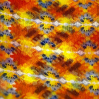 A close-up of the fabric of the Bijoux Terner Beach Printed Pareo reveals a vibrant abstract floral print in shades of yellow and orange. The fluid, flowing design creates a sense of movement, with the warm tones evoking a sunny, tropical atmosphere. The lightweight fabric enhances the soft, relaxed feel of the print, making it ideal for beachwear or casual summer styling.